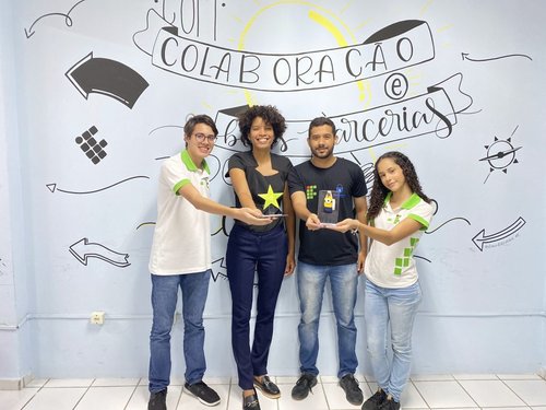 Pedro Godoy e Mariana Caldas, estudantes e membros da miniempresa Connectag, com os prêmios recebidos pela Junior Achievement.