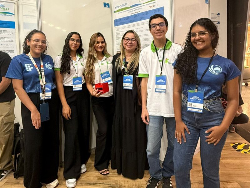 Professora Thayse Azevedo (centro) e alunos em evento de iniciação científica